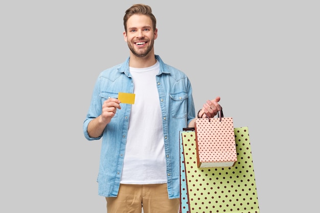 Retrato de un joven apuesto con bolsas de la compra.