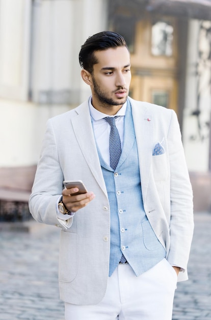 Retrato de un joven apuesto y elegante con cerdas de pie al aire libre