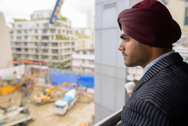 Retrato de joven apuesto empresario sij indio con turbante mientras explora la ciudad de Bangkok, Tailandia