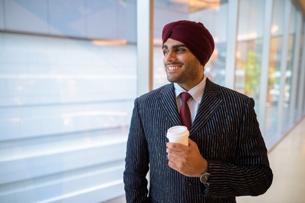 Retrato de joven apuesto empresario sij indio con turbante mientras explora la ciudad de Bangkok, Tailandia