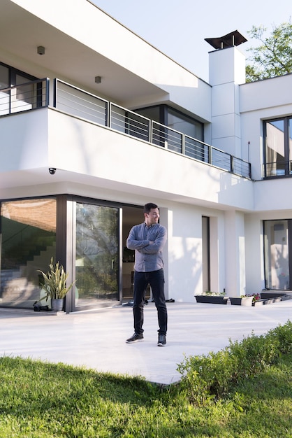 Foto retrato de un joven apuesto y exitoso frente a su villa de lujo