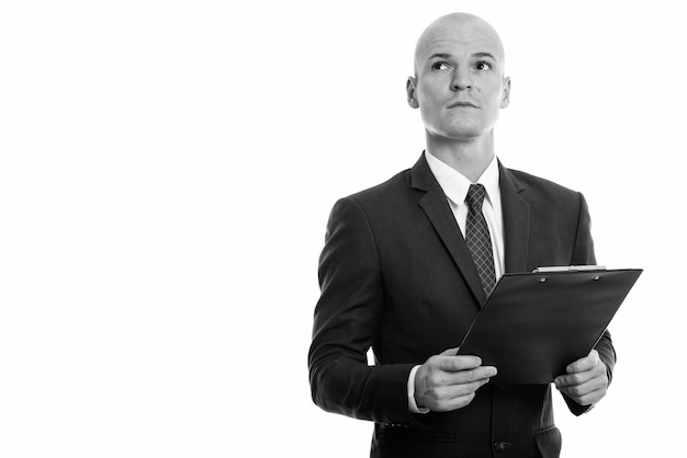 Retrato de joven apuesto hombre de negocios Calvo en traje aislado en blanco en blanco y negro