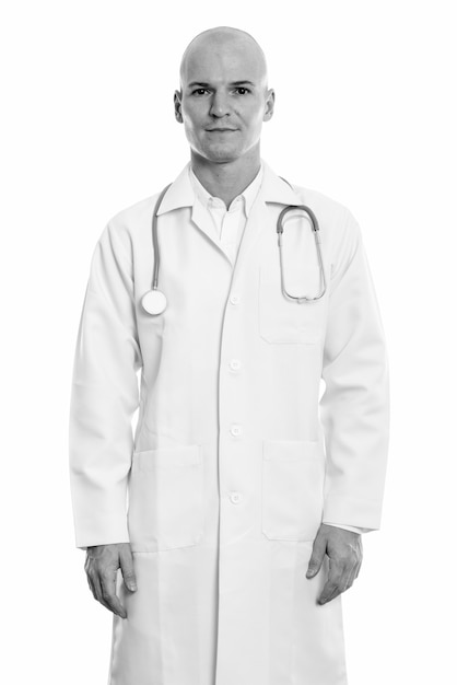 Retrato de joven apuesto médico calvo aislado en blanco en blanco y negro