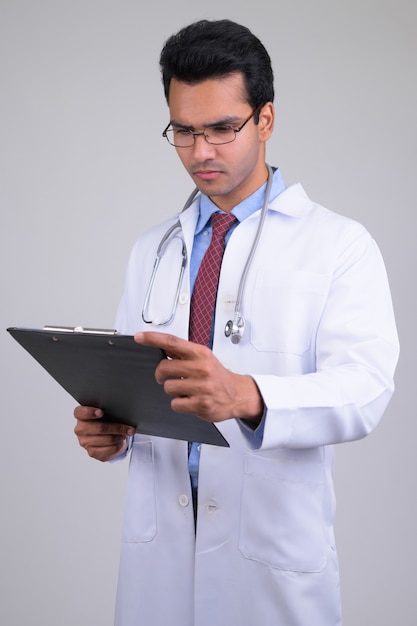 Retrato de joven apuesto médico indio sobre blanco