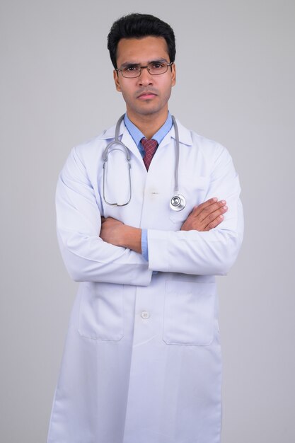 Retrato de joven apuesto médico indio sobre blanco