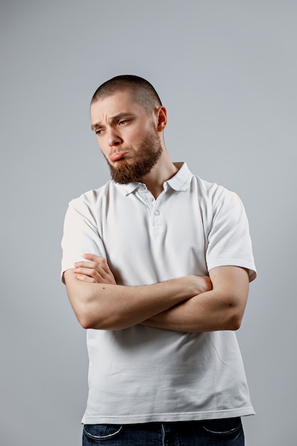 Retrato de un joven apuesto que parece molesto a un lado en gris