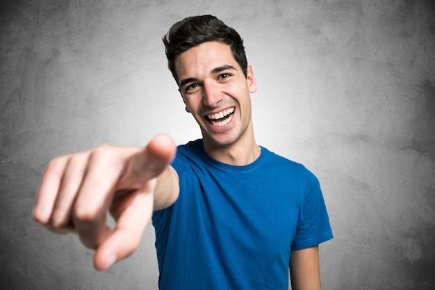 Retrato de un joven apuntando su dedo hacia ti