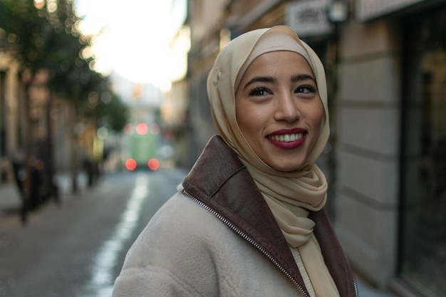 Retrato de una joven árabe hermosa mujer con un pañuelo tradicional sonriendo alegremente a la cámara