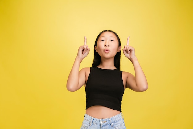 Retrato de joven asiática aislada sobre fondo amarillo studio