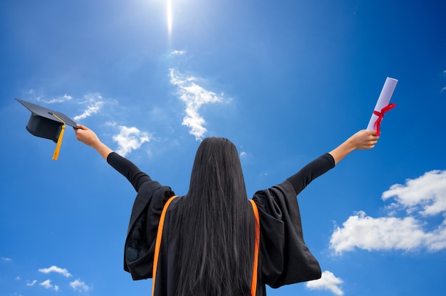 Retrato de joven asiática con diploma de graduación al aire libre