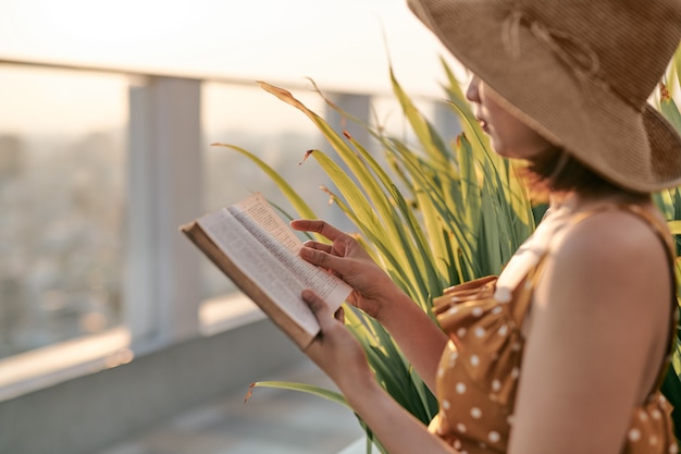 Retrato de joven asiática está leyendo el libro en la azotea del edificio.