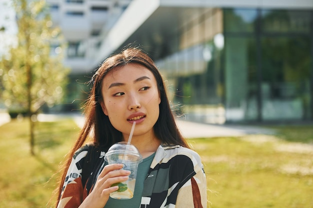 Retrato de una joven asiática que está al aire libre durante el día