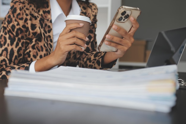 Retrato de una joven asiática que trabaja como freelancer en una tableta de computadora en una oficina moderna haciendo análisis de contabilidad, informes, datos de inversiones inmobiliarias, conceptos de sistemas financieros e fiscales.