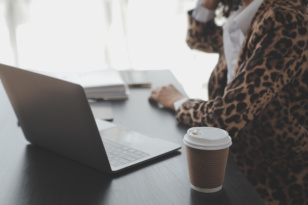 Retrato de una joven asiática que trabaja como freelancer en una tableta de computadora en una oficina moderna haciendo análisis de contabilidad, informes, datos de inversiones inmobiliarias, conceptos de sistemas financieros e fiscales.