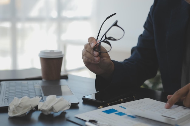 Retrato de una joven asiática que trabaja como freelancer en una tableta de computadora en una oficina moderna haciendo análisis de contabilidad, informes, datos de inversiones inmobiliarias, conceptos de sistemas financieros e fiscales.