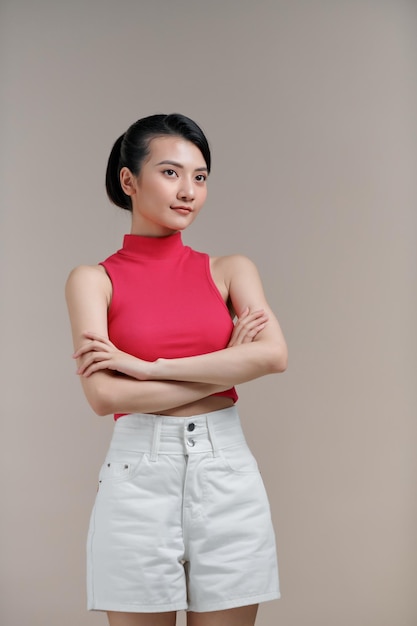 Retrato de una joven asiática sonriente con los brazos cruzados
