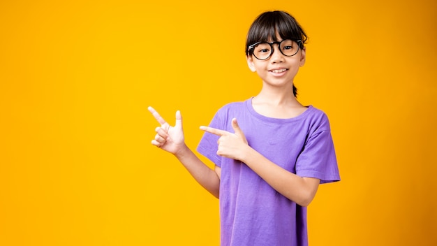 Retrato de joven asiática sonrió y señaló para copiar espacio para texto o productos