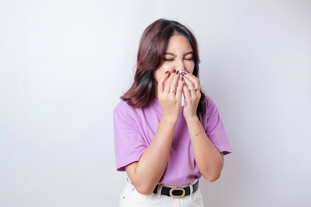 Retrato de una joven asiática triste y disgustada con bufanda que se suena la nariz y se limpia la nariz con un pañuelo Problemas de salud fiebre enfermedad gripe fría y espacio de copia del virus covid19