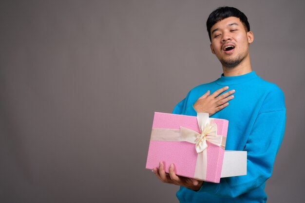 Retrato de joven asiático con caja de regalo