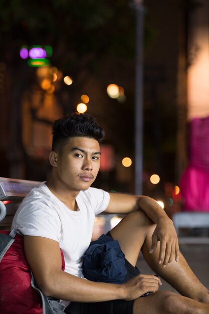 Retrato de joven asiático en la calle de la ciudad por la noche al aire libre
