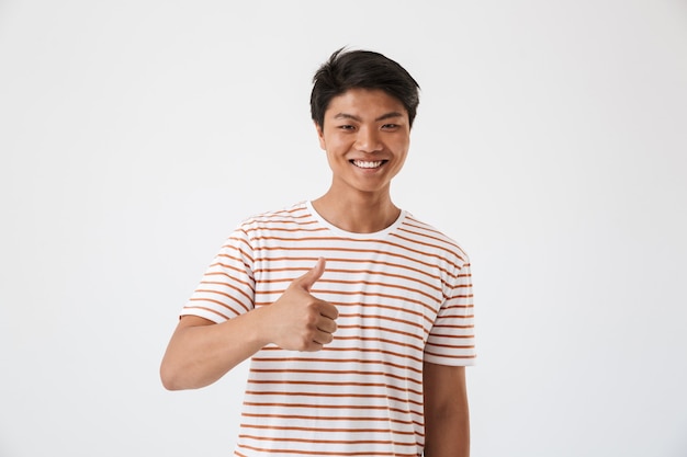 Retrato de un joven asiático feliz mostrando los pulgares para arriba