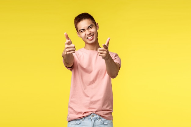 Retrato de un joven asiático mostrando gesto sobre pared amarilla