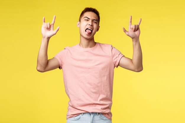 Retrato de un joven asiático mostrando gesto sobre pared amarilla