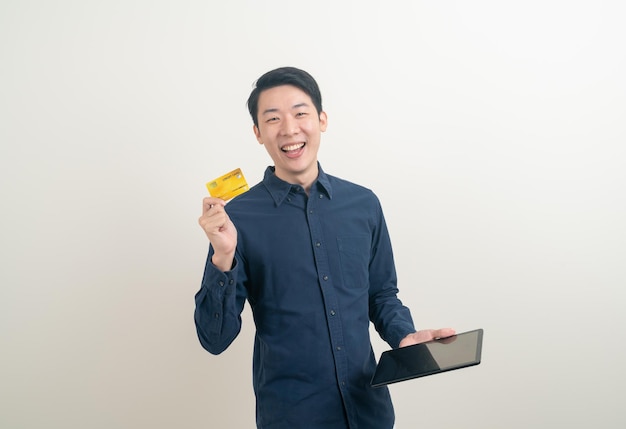 Retrato joven asiático con tarjeta de crédito y tableta
