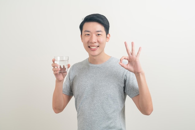 Retrato joven asiático con un vaso de agua en la mano