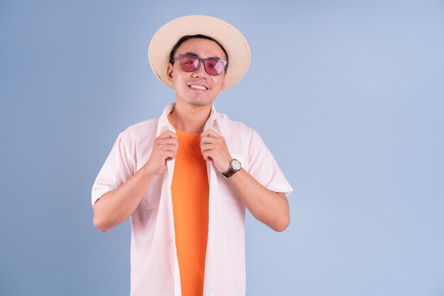 Retrato de joven asiático vistiendo ropa de verano sobre fondo azul.