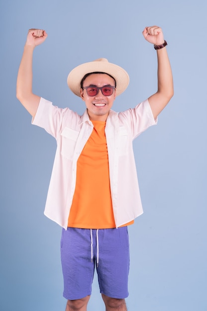 Retrato de joven asiático vistiendo ropa de verano sobre fondo azul.