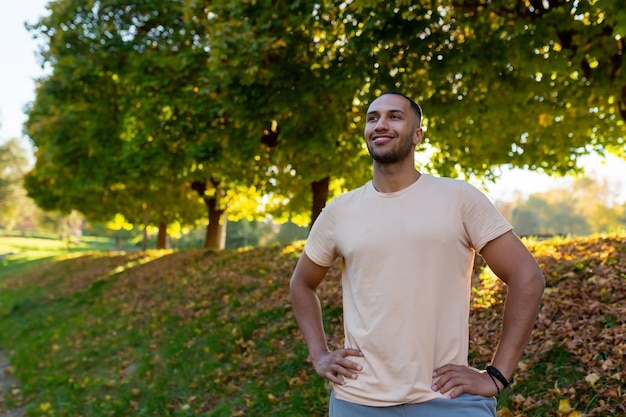 Retrato de un joven atleta afroamericano de pie en un parque en un atleta corredor de uniforme deportivo