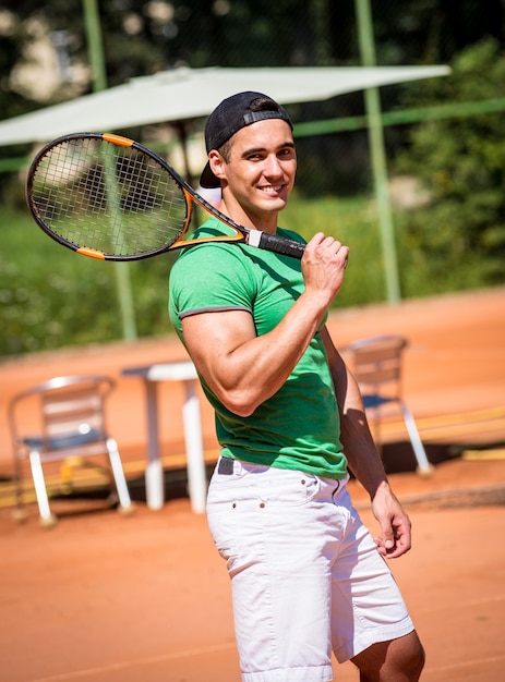 Retrato de joven atlético en la cancha de tenis