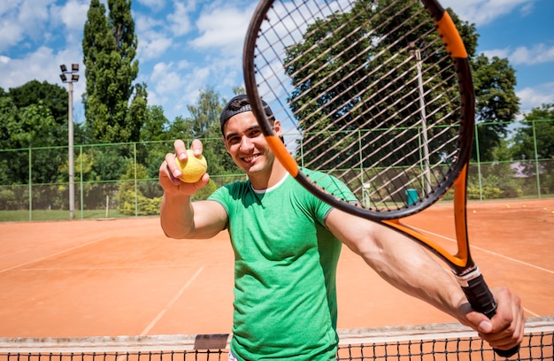 Retrato de joven atlético en la cancha de tenis