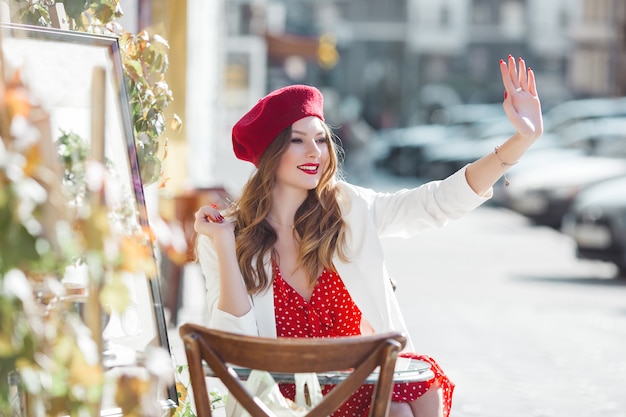 Retrato de joven atractiva al aire libre. Bella dama urbana sonriendo. Mujer con labios rojos.