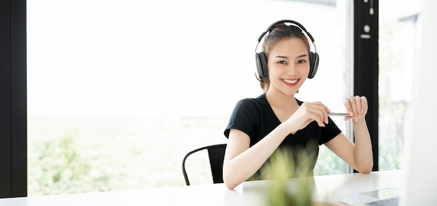 Retrato de una joven atractiva con auriculares sonriendo a la cámara