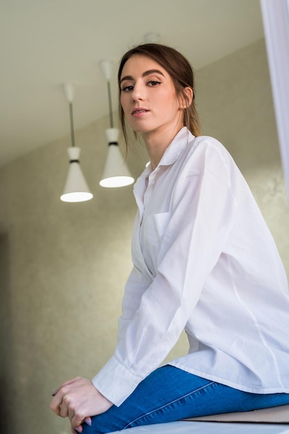 Retrato de joven atractiva junto a la pared, sesión de fotos de estudio