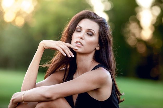 Foto retrato de joven atractiva sentada sobre fondo verde borroso