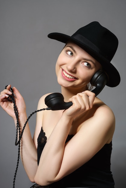 Retrato de joven atractiva con teléfono vintage