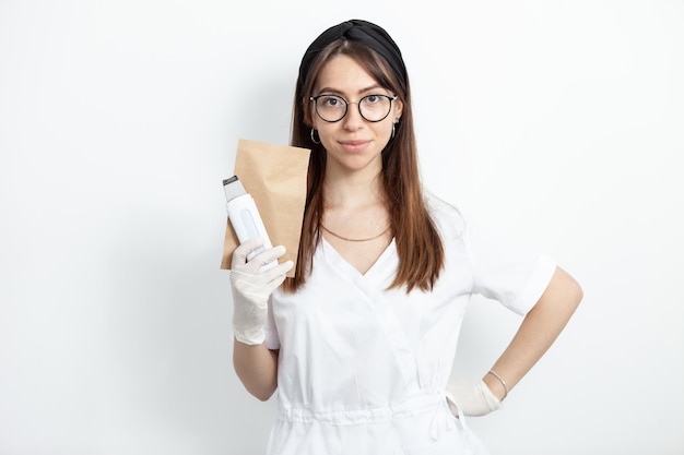 Retrato de joven atractivo médico esteticista con herramienta cosmética ultrasónica