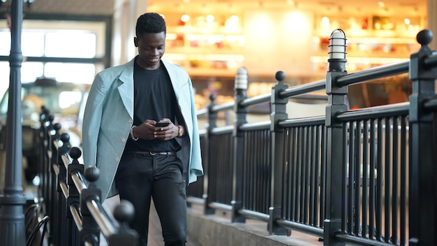 Retrato de un joven y atractivo modelo afroamericano con estilo posando con ropa informal en un fondo neutro que se ve sexy con el pelo afro. En Gente Juventud Concepto de belleza y moda.