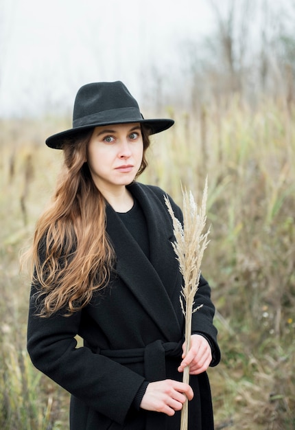 Retrato, de, joven, atractivo, mujer, en, abrigo negro, y, sombrero