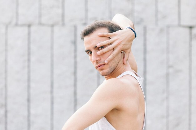 Foto retrato de un joven bailando contra la pared