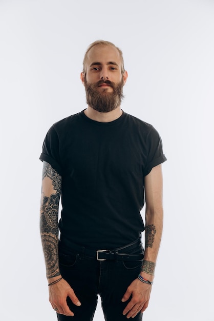 Retrato de un joven con barba en una camiseta negra sobre un hipster de fondo blanco