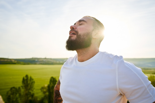 Retrato de joven barbudo al aire libre en las montañas