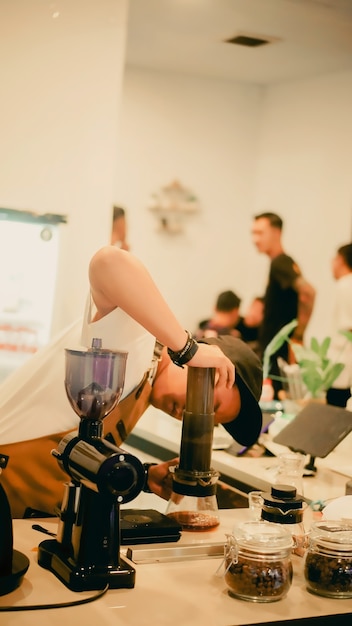 Retrato de un joven barista haciendo café con el método aeropress