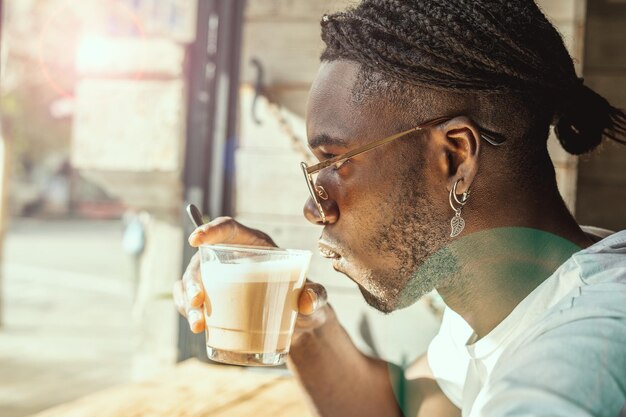 Foto retrato de un joven bebiendo café