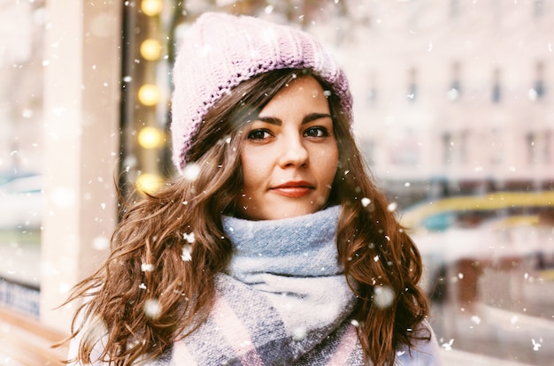 Retrato de joven bella mujer en abrigo y sombrero disfrutando del fi