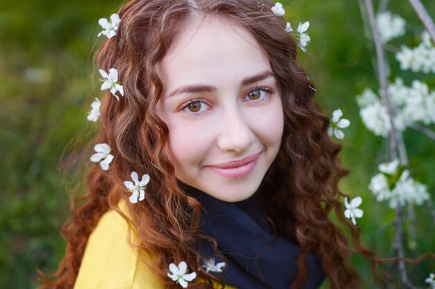 Retrato de joven bella mujer en árboles de flor de primavera