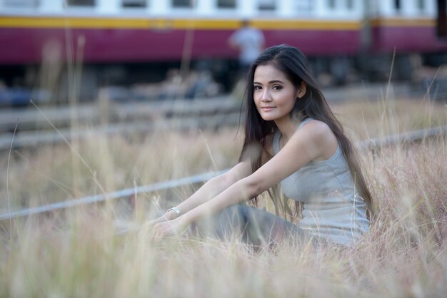 Retrato de joven bella mujer asiática en la estación de tren